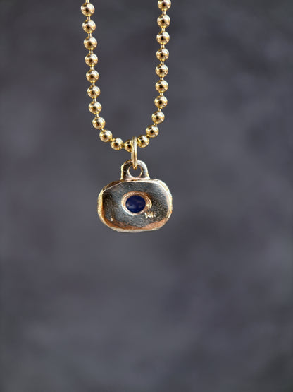 Necklace with a pendant featuring a blue stone on a dark background