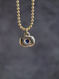 Necklace with a pendant featuring a blue stone on a dark background