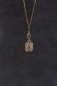 Gold pendant necklace on a dark textured background